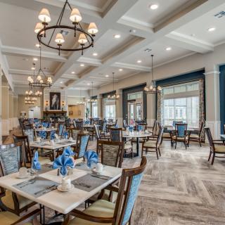 An elegant dining area featuring chandeliers and neatly arranged table settings.