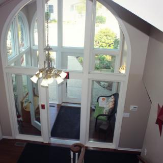 Interior view of a lobby with glass doors and a chandelier.