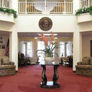 A well-decorated lobby with comfortable seating and a central floral arrangement.