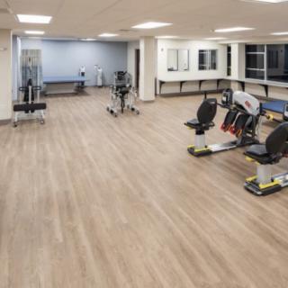 A spacious gym with various exercise equipment and a clean, modern design.