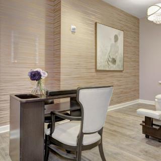 A minimalist office space featuring a desk, chair, and wall art.