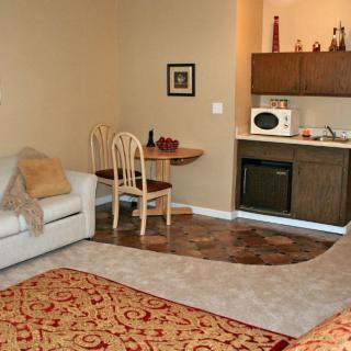 A cozy living area with a sofa, small dining table, and kitchenette.