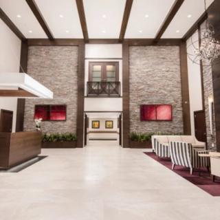 A spacious and modern hotel lobby with a reception desk and seating area.