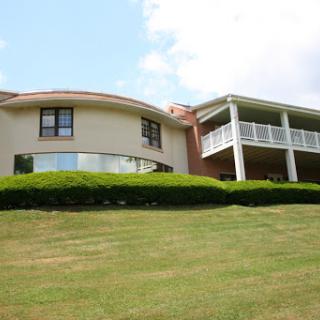 A beautifully designed modern house set on a lush green lawn.