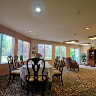 A spacious dining area with a large table and chairs surrounded by windows.