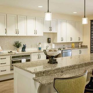 Modern kitchen with a granite countertop and stylish pendant lighting.