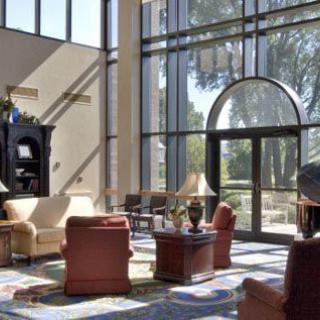 A spacious and modern lobby with large windows allowing abundant natural light, featuring comfortable seating and elegant decor.
