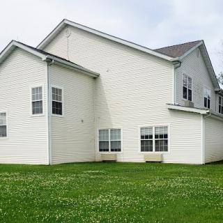 A modern two-story house with white siding and a green lawn.
