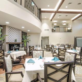 An elegant dining room with neatly arranged tables and chairs, featuring stylish interior design and warm lighting.