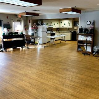 Spacious room with a kitchen area and wooden flooring.