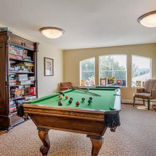 A cozy game room featuring a pool table and a well-stocked bookshelf.