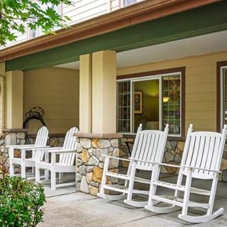 A cozy porch featuring white rocking chairs ideal for relaxation.