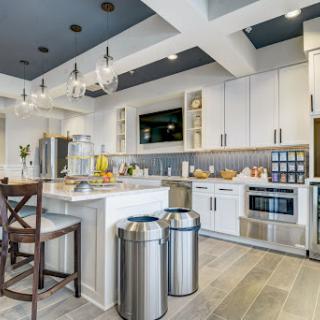 A beautifully designed modern kitchen featuring white cabinetry, stainless steel appliances, and elegant lighting.