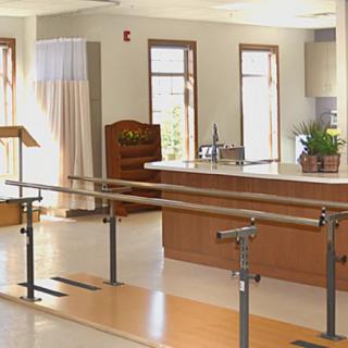 A rehabilitation room with parallel bars used for physical therapy.