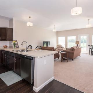 A modern open-concept kitchen and living room with ample natural light and stylish furnishings.
