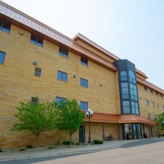 A modern urban building with a brick facade and multiple windows.