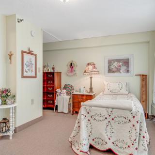 A cozy bedroom with vintage decor and a single bed adorned with a lace coverlet.