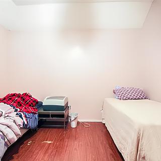 A minimalist bedroom featuring two single beds with simple bedding.