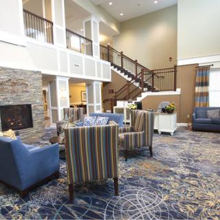 Spacious hotel lobby with modern seating and a central staircase.
