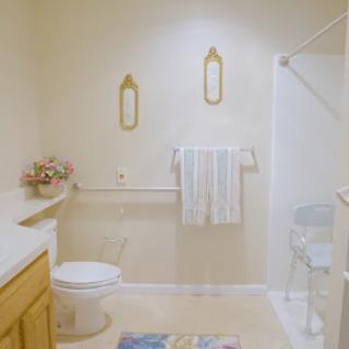 A bright and tidy bathroom featuring a shower, towels neatly hung, and minimalist decor.