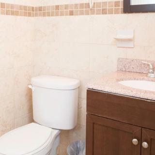 A clean and modern bathroom with a toilet and a sink cabinet.
