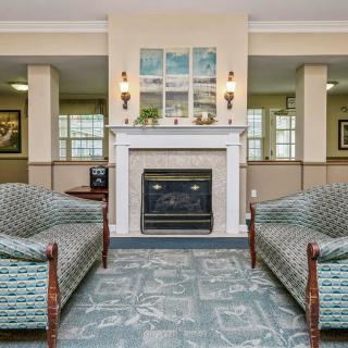 A traditional living room featuring a central fireplace, two upholstered sofas, and stylish artwork above the mantel.