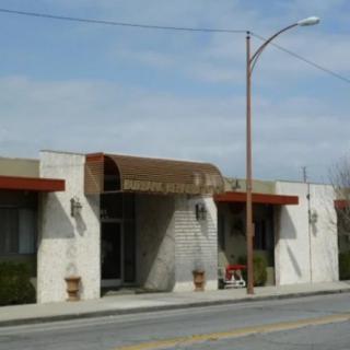 A street view of a building with an awning and outdoor lighting.