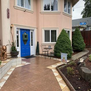 A charming house with a blue door and a neatly landscaped front yard.