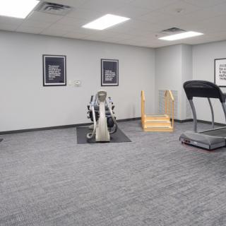 A small gym with exercise equipment including a treadmill and a stationary bike.