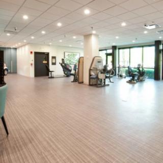 A spacious and modern gym featuring various exercise equipment.