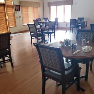 An empty dining area in a restaurant with neatly arranged tables and chairs.