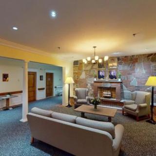 A cozy living room with sofas, lamps, and a fireplace.