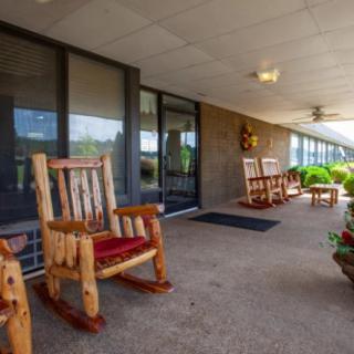 A cozy porch with wooden rocking chairs and potted plants, providing a relaxing outdoor space.