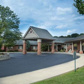 A modern building entrance with a covered driveway and landscaping.