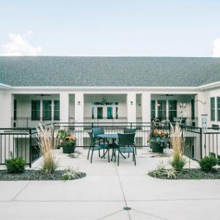A serene residential courtyard featuring well-maintained landscaping and outdoor furniture.