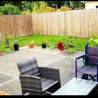 A cozy backyard patio with outdoor seating and potted plants.