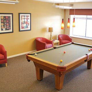 A cozy game room featuring a pool table and comfortable seating.