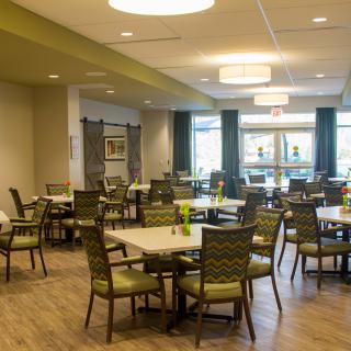 A modern dining area with neatly arranged tables and chairs, featuring contemporary decor and ample lighting.
