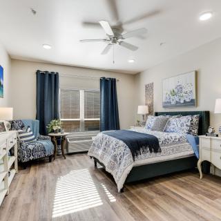 A modern bedroom with elegant decor, featuring wood flooring and stylish furnishings.