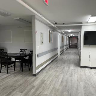 A long corridor with modern flooring and furniture in a building interior.
