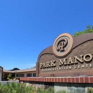 The sign for Park Manor Rehabilitation Center under a clear blue sky.