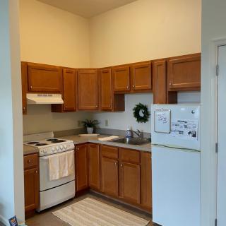 A cozy kitchen with wooden cabinets and standard appliances.