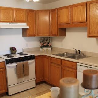 A tidy kitchen with wooden cabinets and essential appliances.