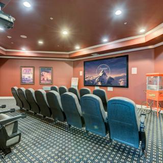 A cozy home theater room with rows of seating, movie posters on the walls, and a large screen for an immersive viewing experience.