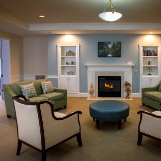 A cozy living room with a fireplace, comfortable seating, and traditional decor.