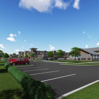 A modern architectural complex with a parking lot under a clear blue sky.