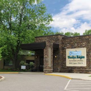 Entrance to a building with stone exterior and surrounding trees.