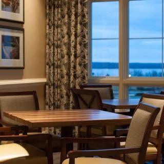 A cozy dining area with a wooden table and chairs, featuring a window with a scenic view.