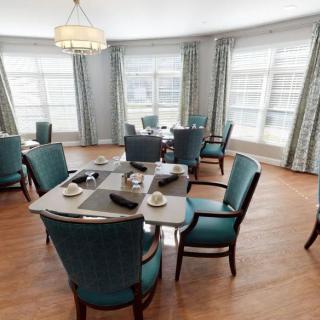 A well-lit dining room with elegant dcor and multiple tables set for guests.