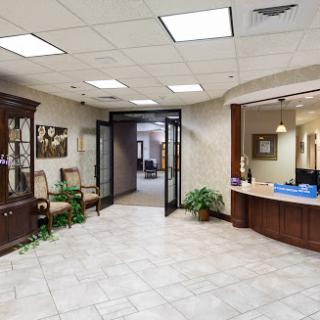 A welcoming reception area with a modern design, featuring comfortable seating and lush greenery.